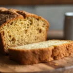 A close-up of sliced snickerdoodle zucchini bread with a golden cinnamon-sugar crust.