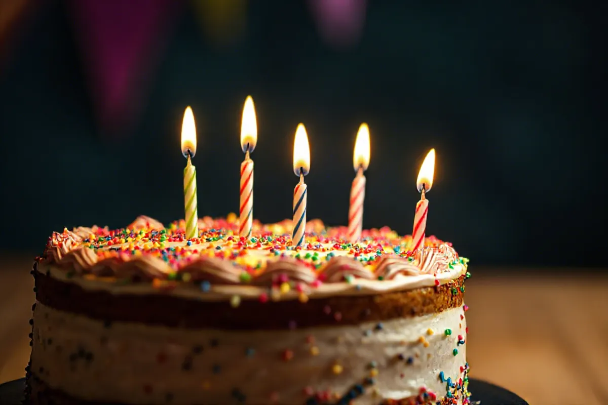 A beautifully decorated happy birthday cake with floral decorations and candles