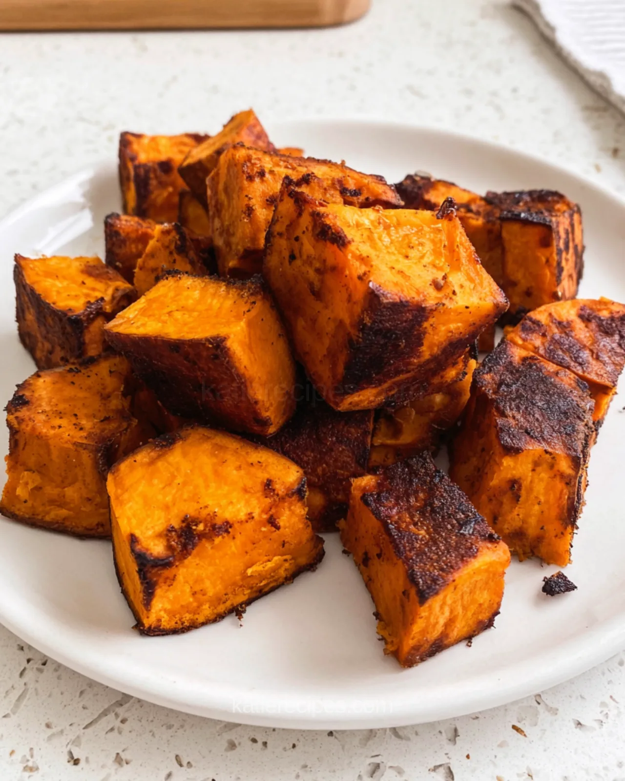 Close-up of air fryer sweet potato cubes showing crisp caramelized edges and soft orange centers