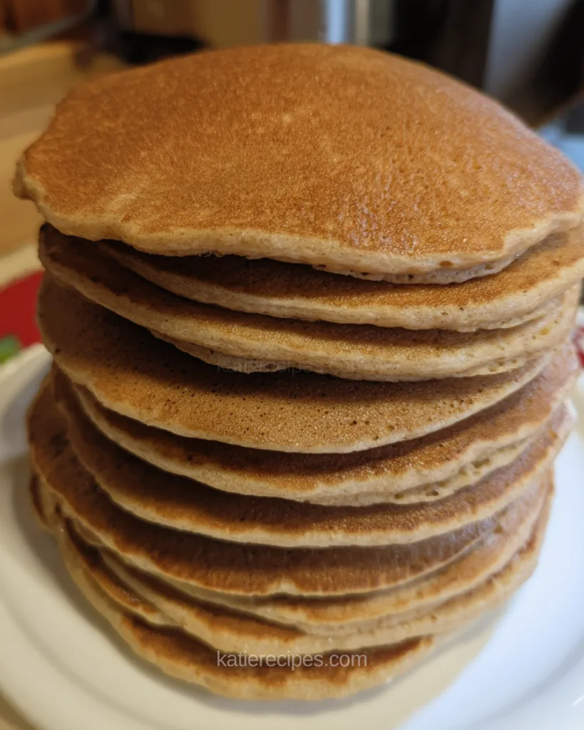 Tall stack of golden brown Kodiak protein pancakes on a white plate