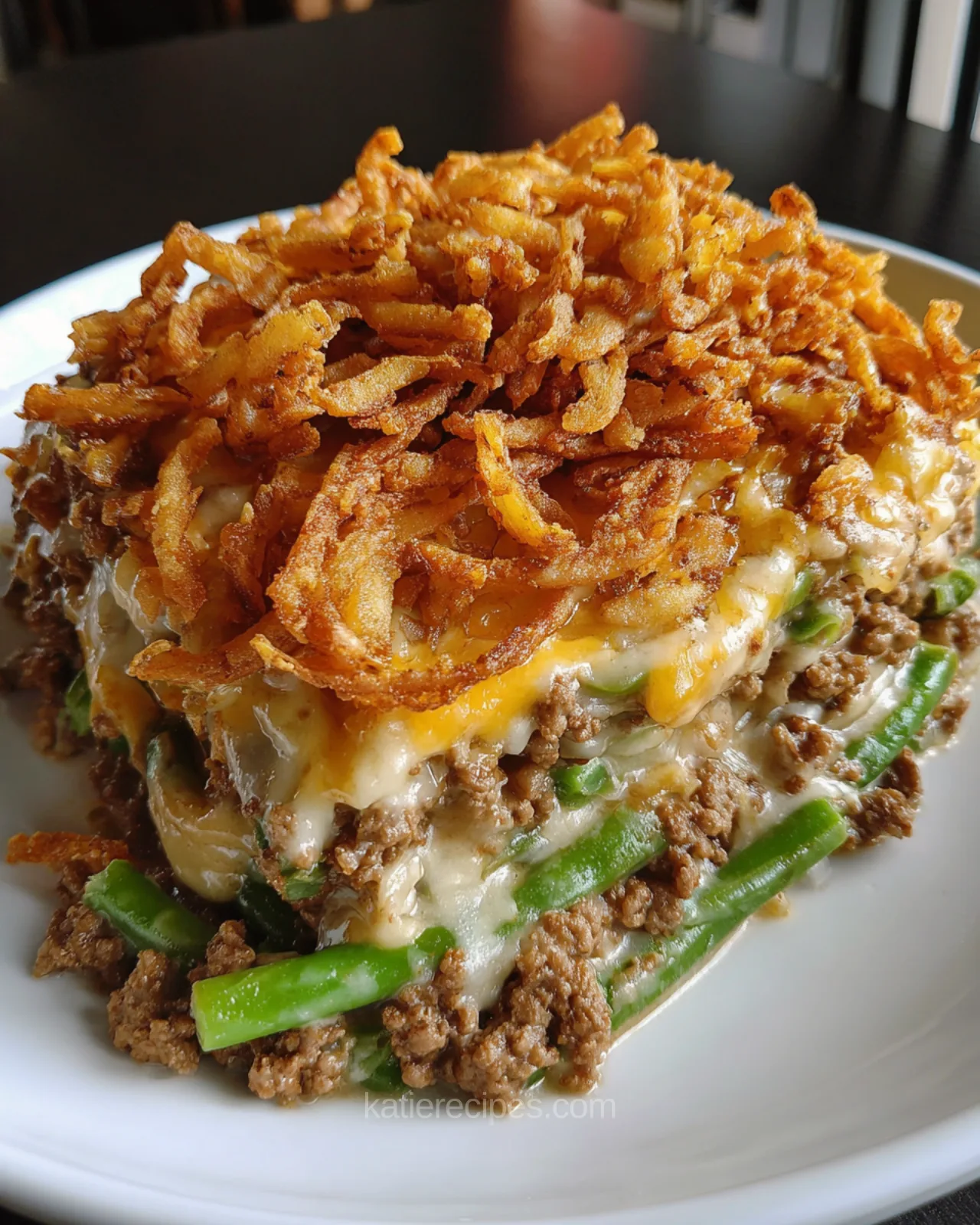 Hamburger green bean casserole baked with ground beef, green beans, melted cheese, and crispy fried onion topping