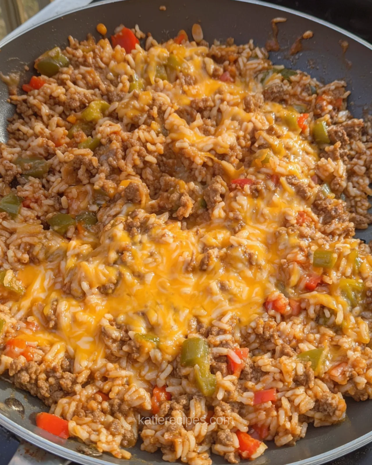 Unstuffed pepper skillet topped with melted cheddar cheese, ground beef, rice, and bell peppers