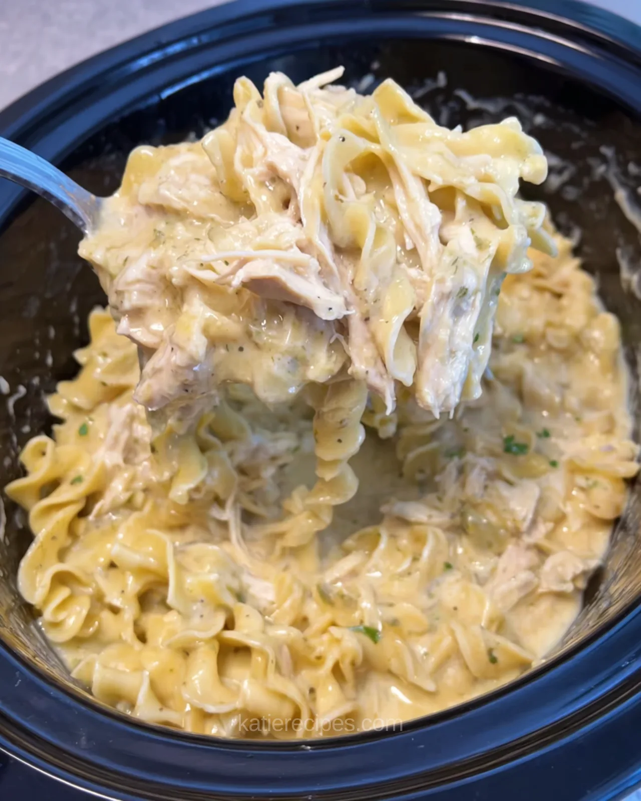 Creamy crockpot chicken and noodles with tender shredded chicken and soft egg noodles in a slow cooker