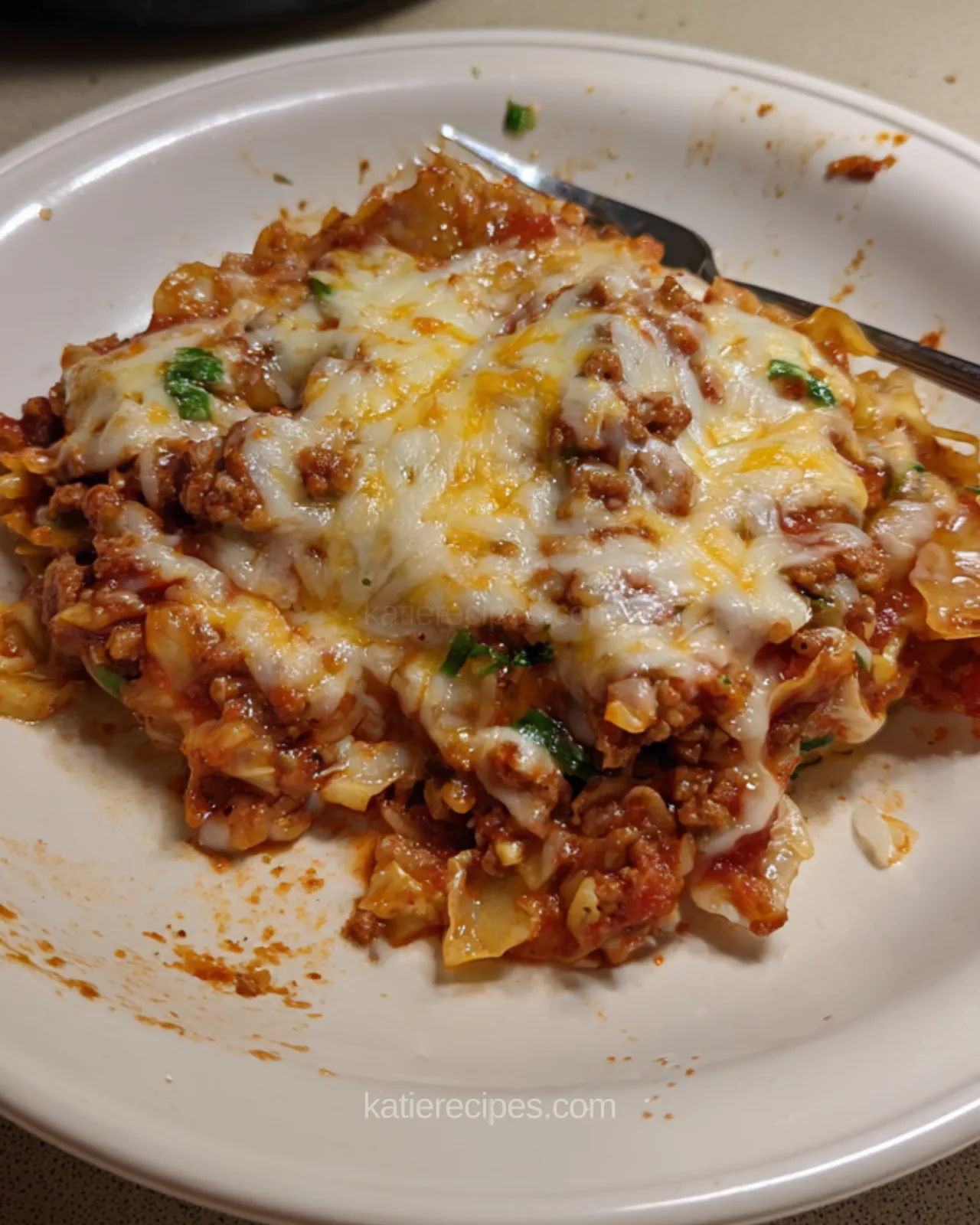 A plated serving of unstuffed cabbage roll skillet topped with melted cheese and parsley