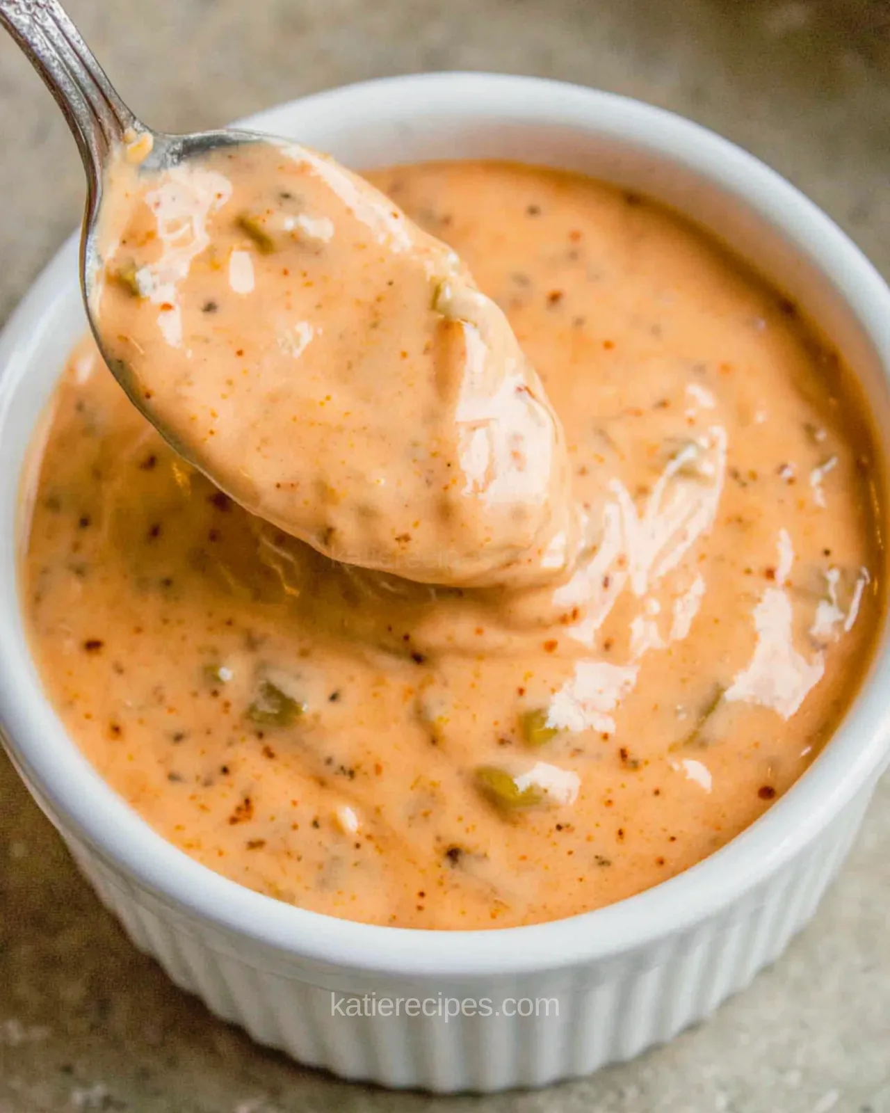 Burger sauce recipe in a white bowl with a spoon, made with mayo, ketchup, and dill pickle relish