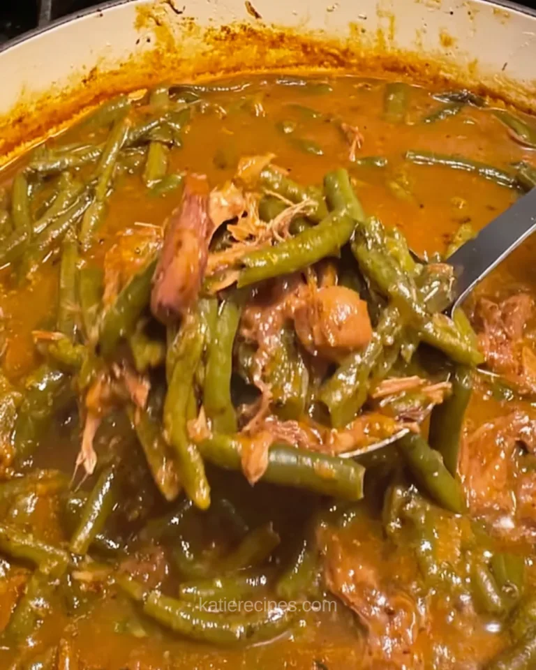 Spoonful of smothered green beans with shredded smoked turkey in smoky gravy